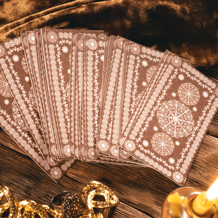 A fan of brown Tarot cards on a brown table surrounded by yellow stones.