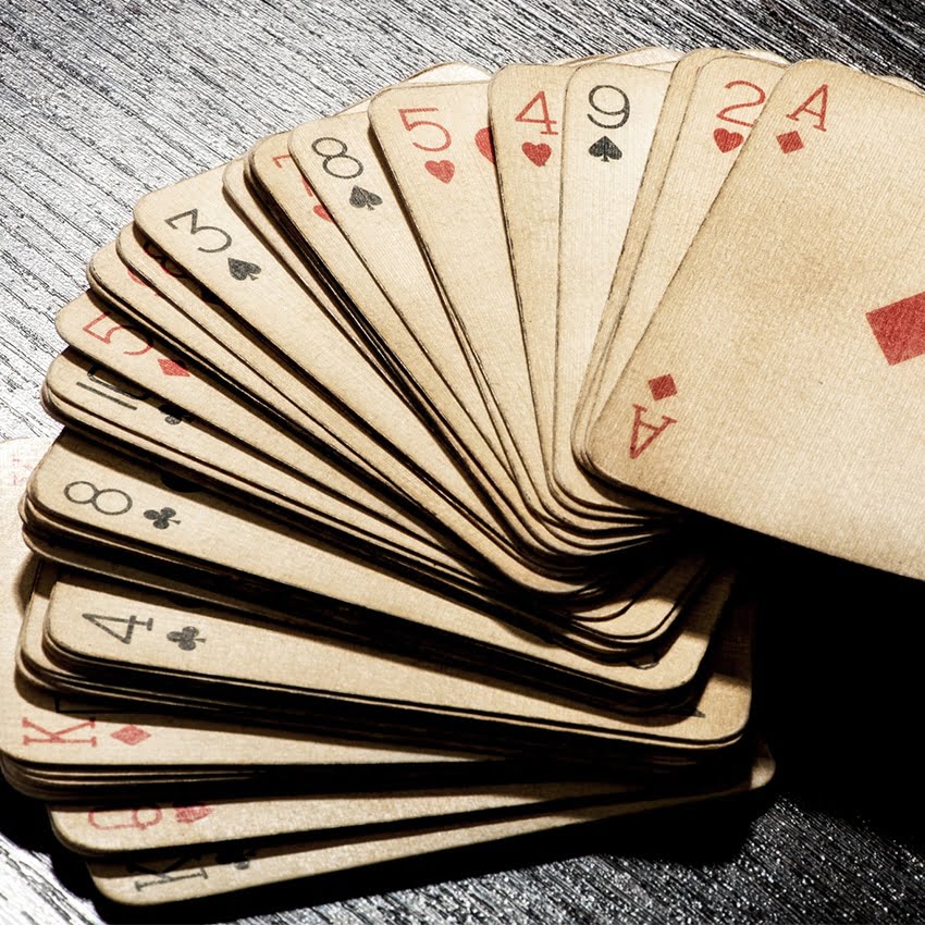A stack of playing cars is spread out in a fan shape, facing upwards.